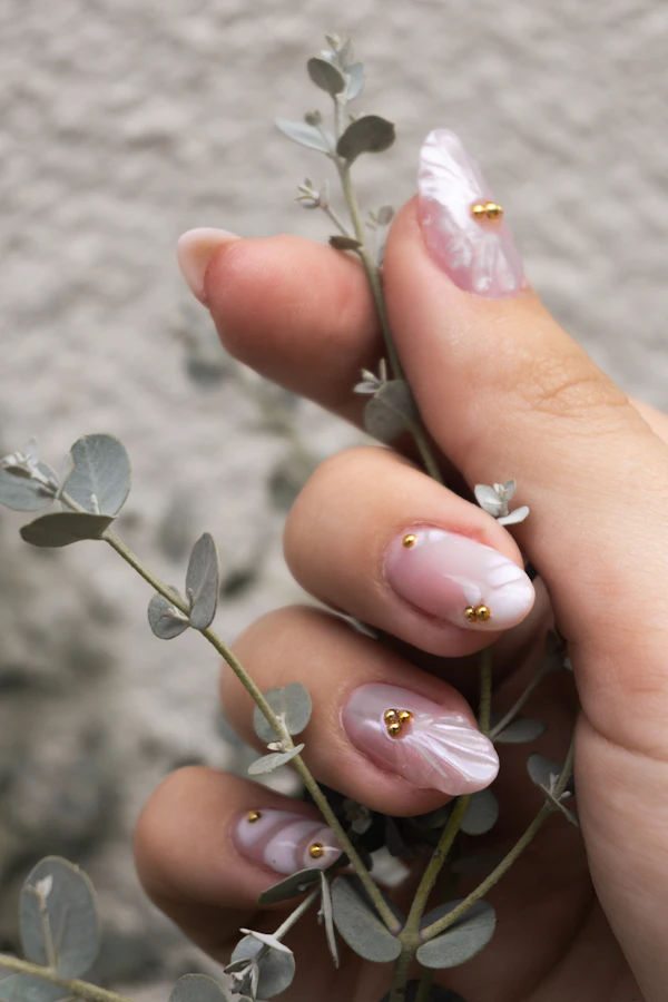 Uñas nude con detalles dorados y eucalipto
