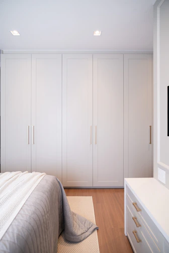 Modern bedroom with large white wardrobe and dresser