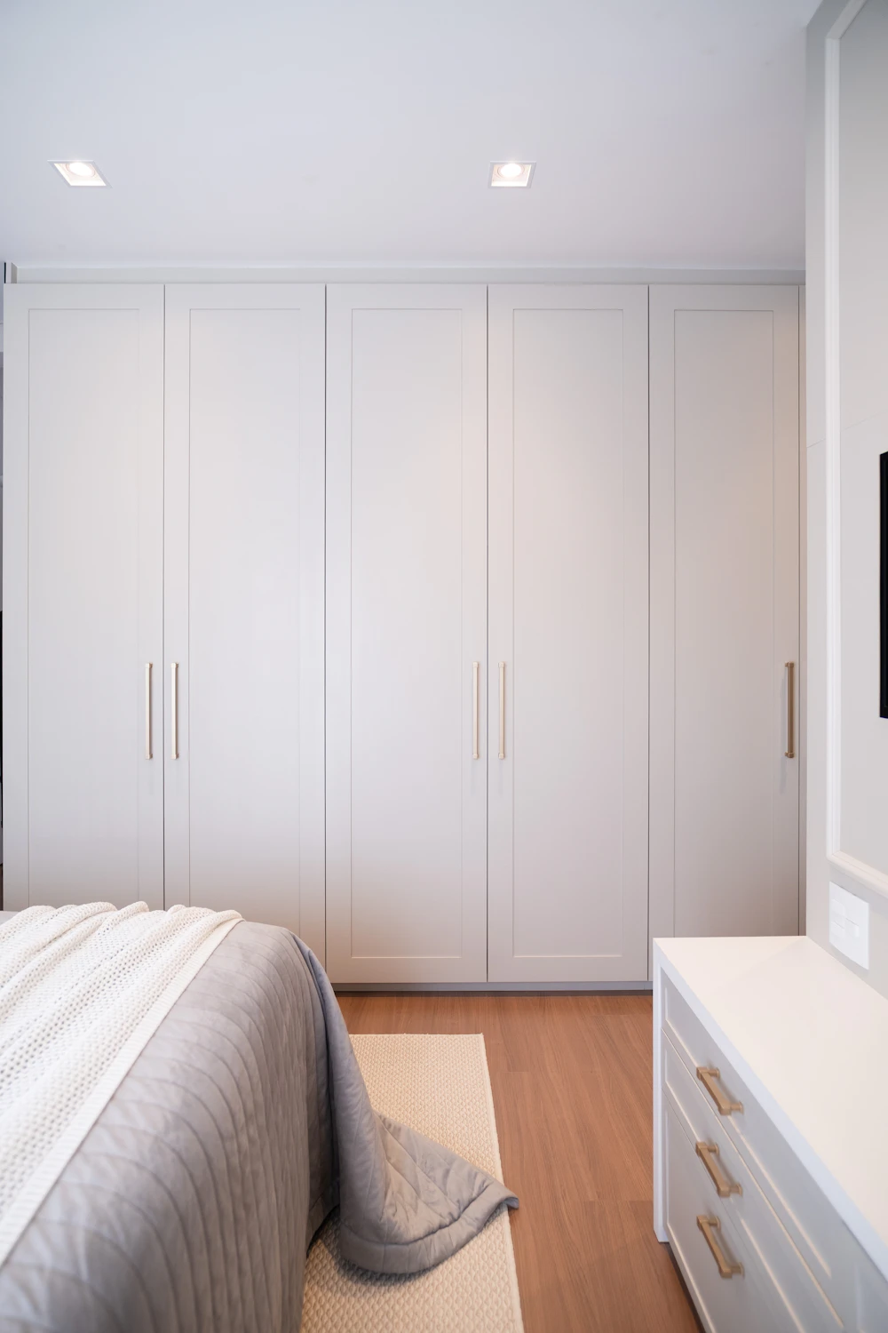 Modern bedroom with large wardrobe and closed storage furniture