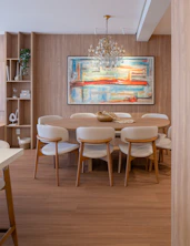 Elegant dining room with abstract art and chandelier.