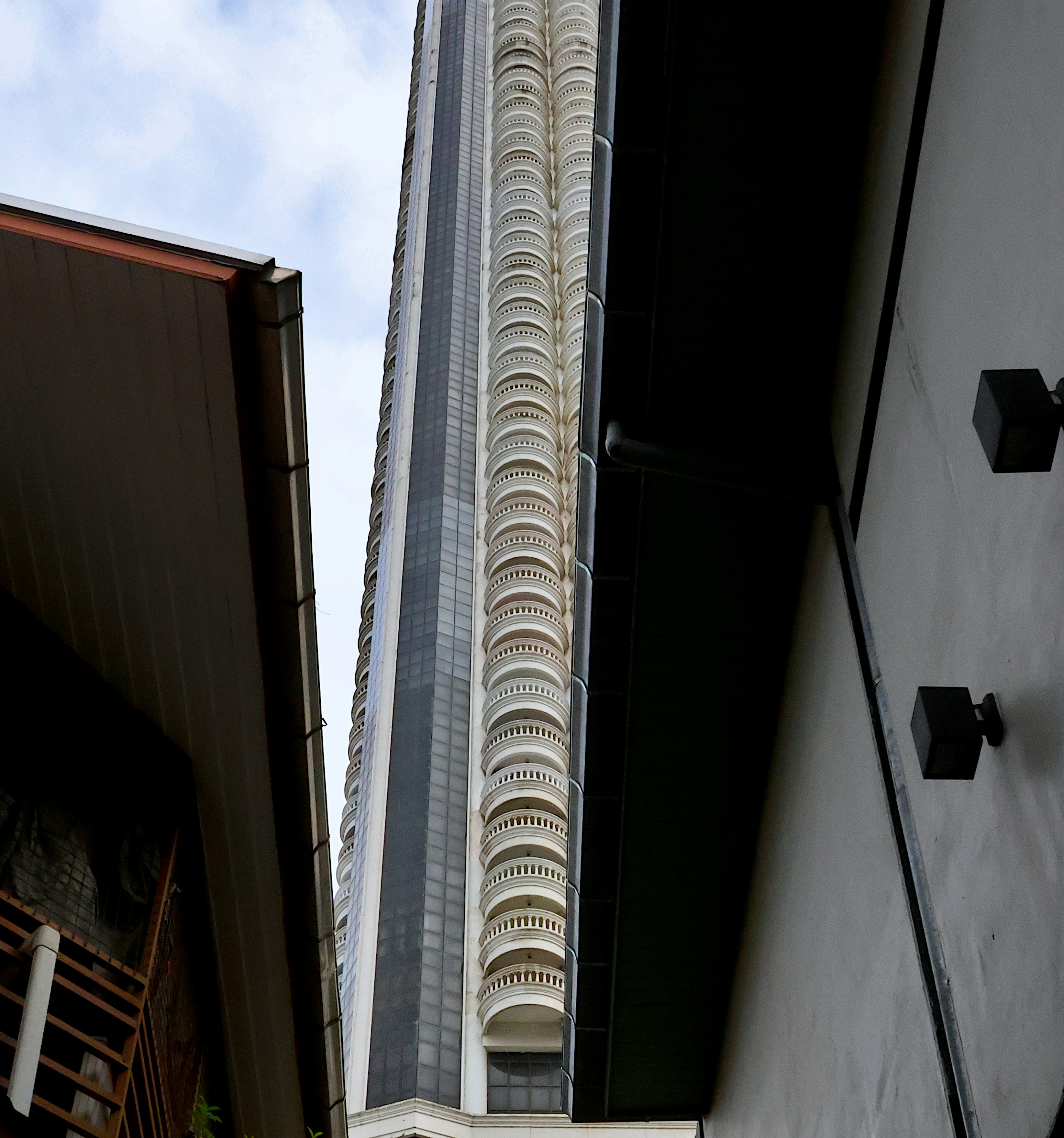 Tall skyscraper with balconies against a cloudy sky