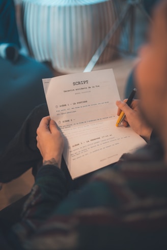 Person reading a script with a pen