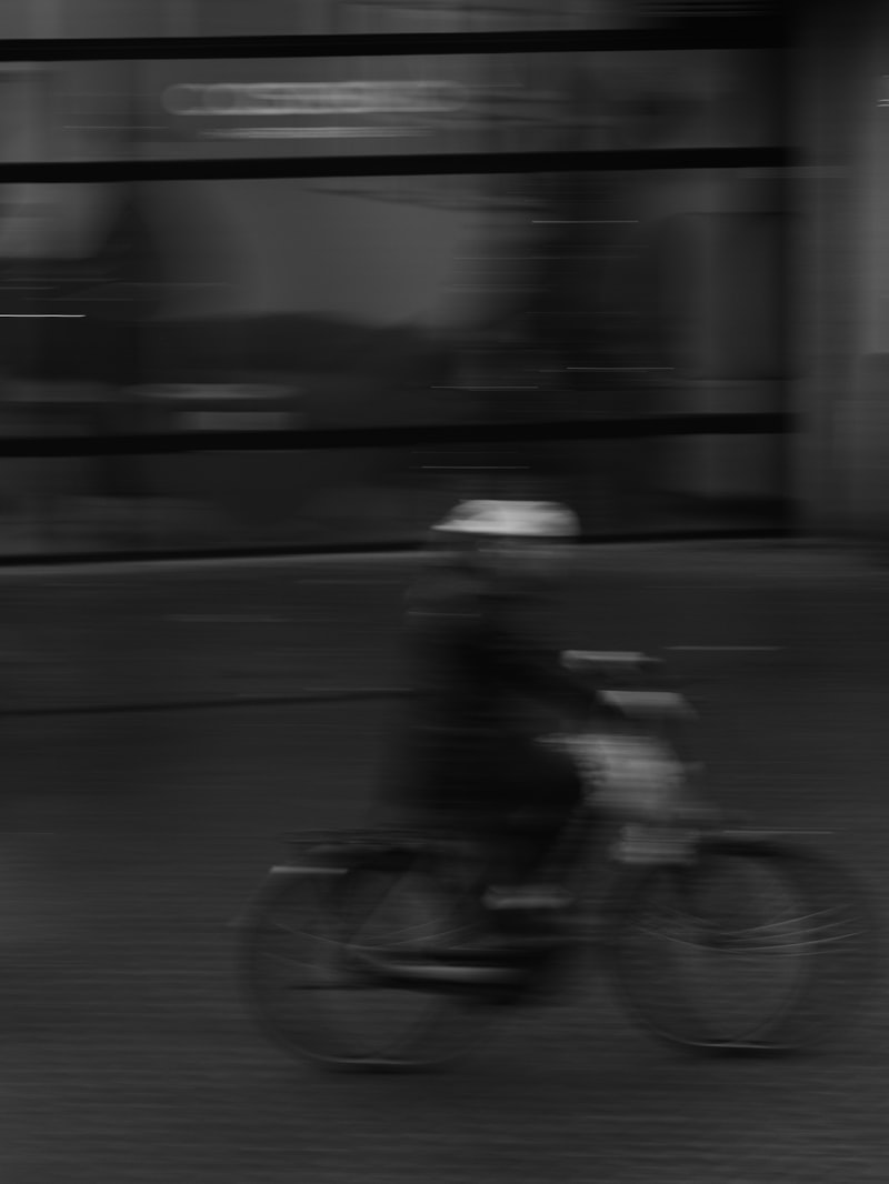 Radfahrer fährt mit Bewegungsunschärfe durch eine Allee