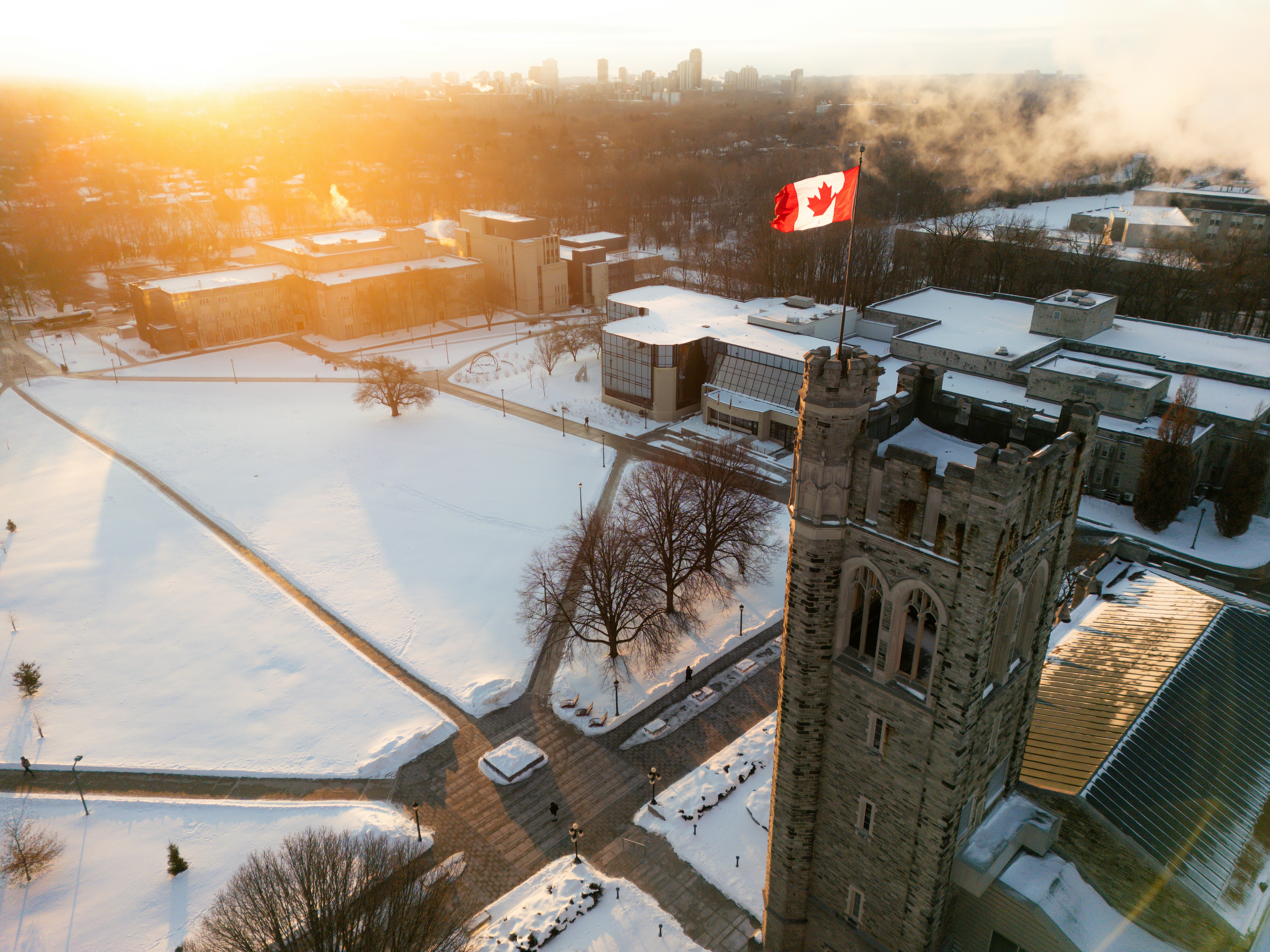 Snowy campus with canadian flag at sunrise