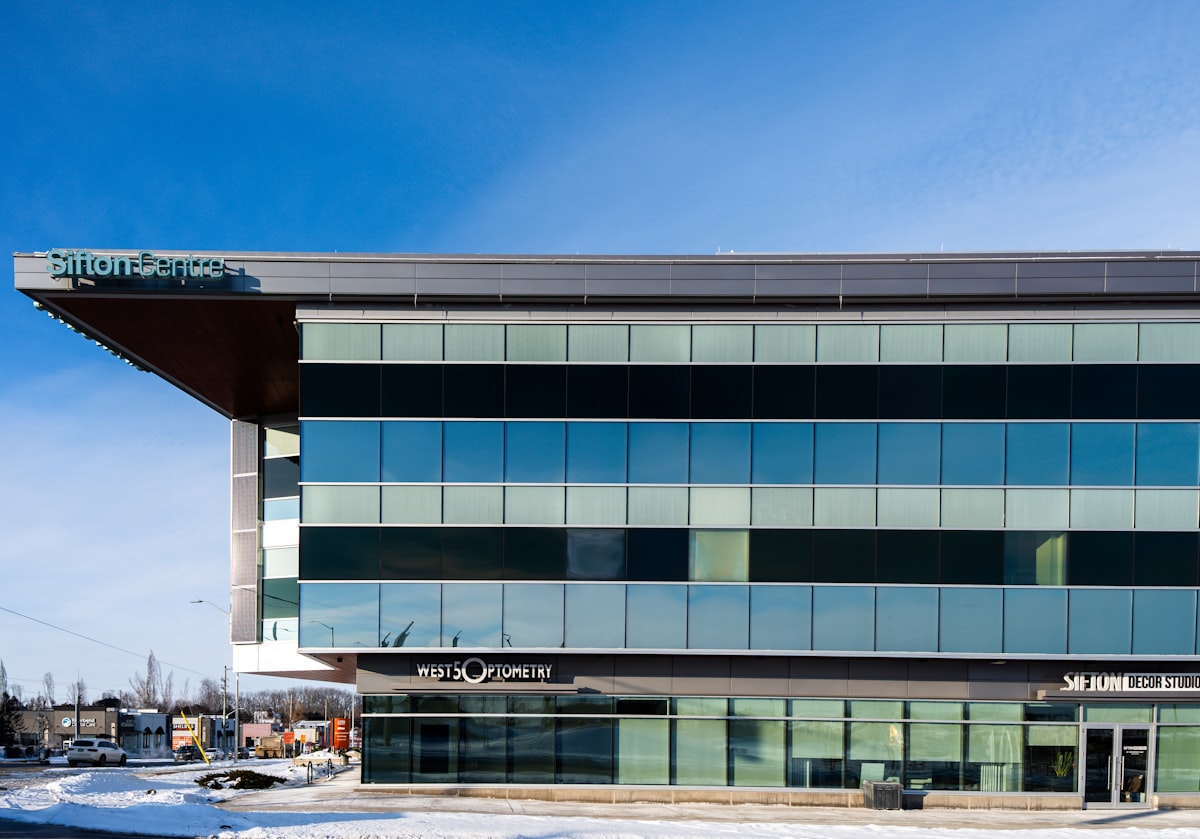Modern glass office building with blue sky reflecting commercial real estate