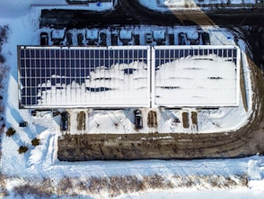 Rooftop solar panels partially covered in snow.