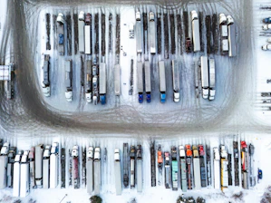 Aerial view of parked semi-trucks in a snowy lot.