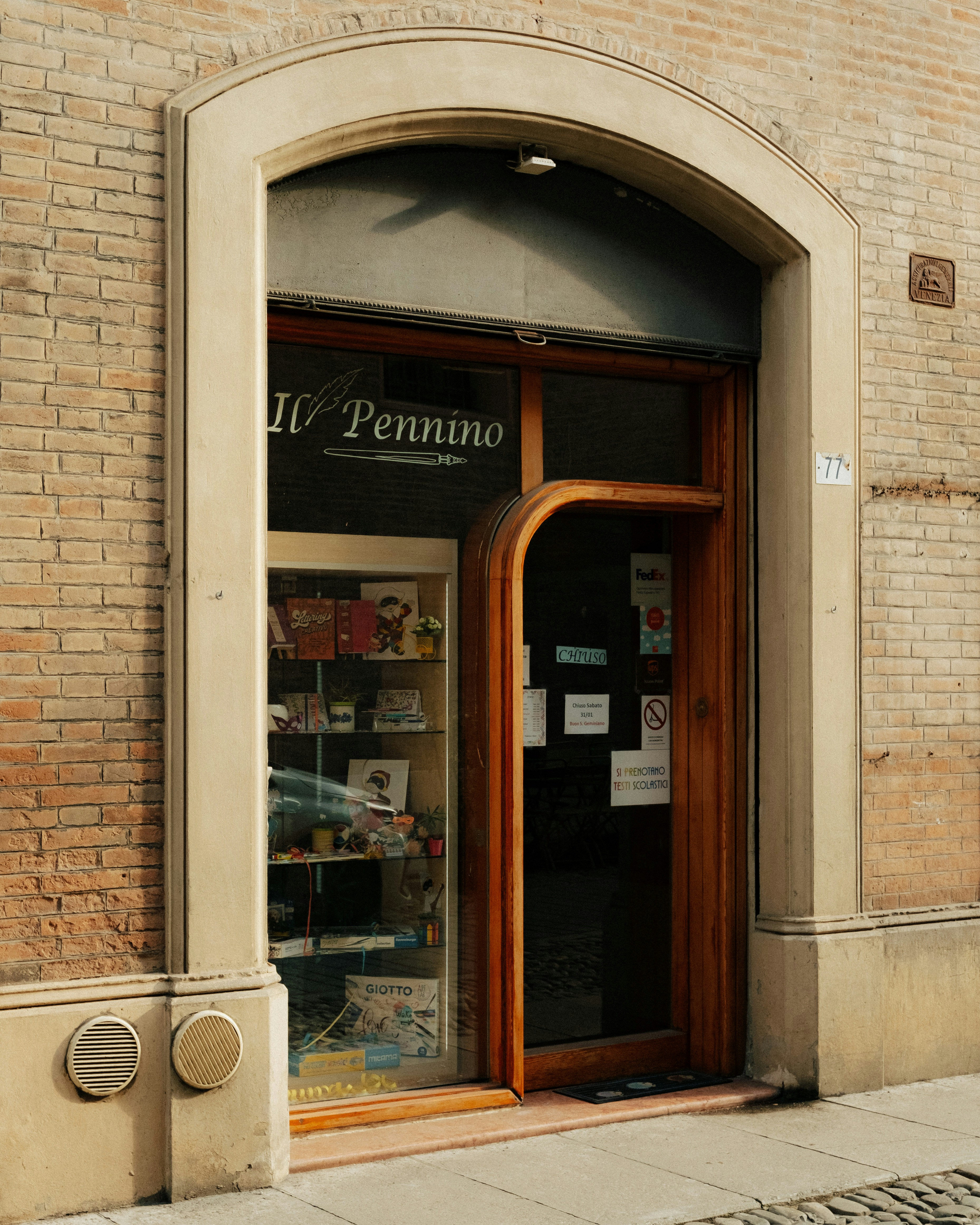 A quaint storefront with an arched entrance and display window