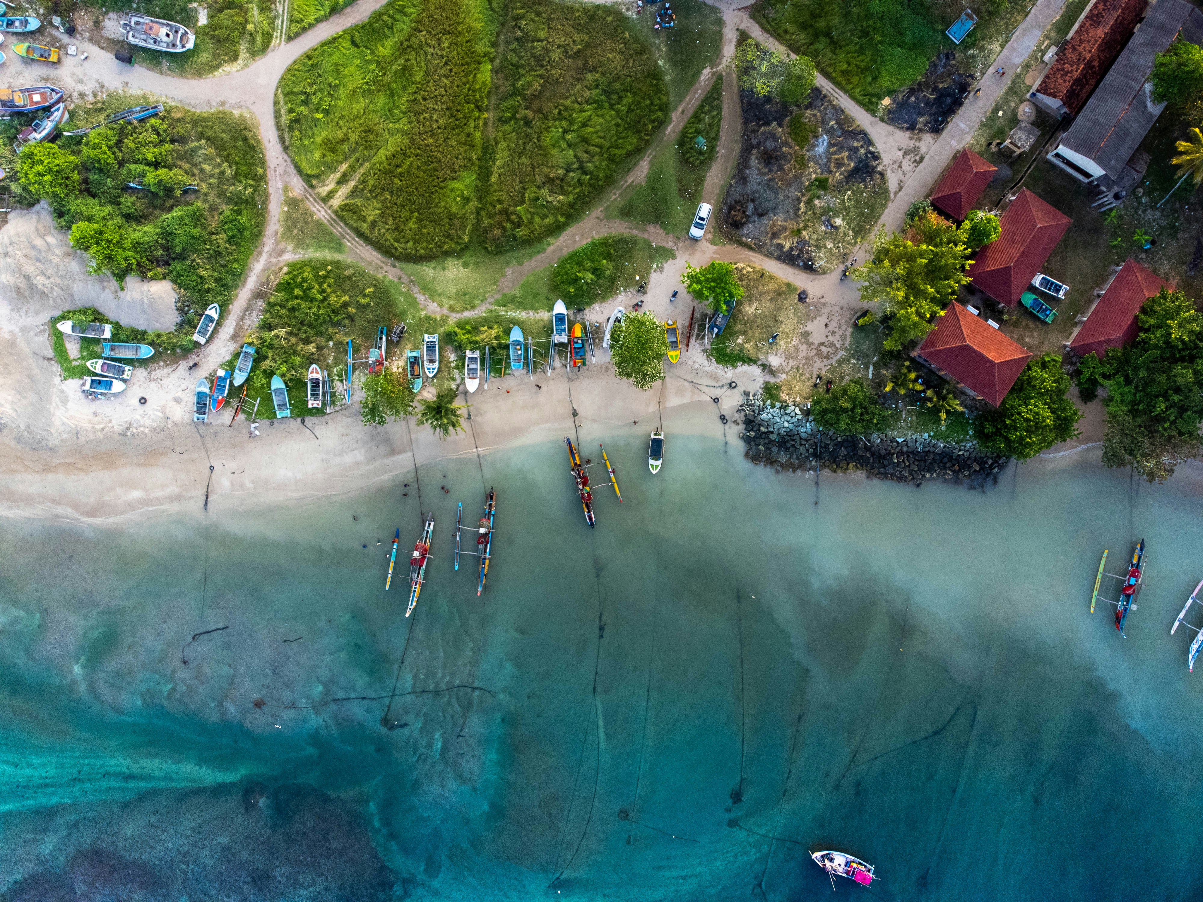 Aerial view of a tropical coastline with boats and houses