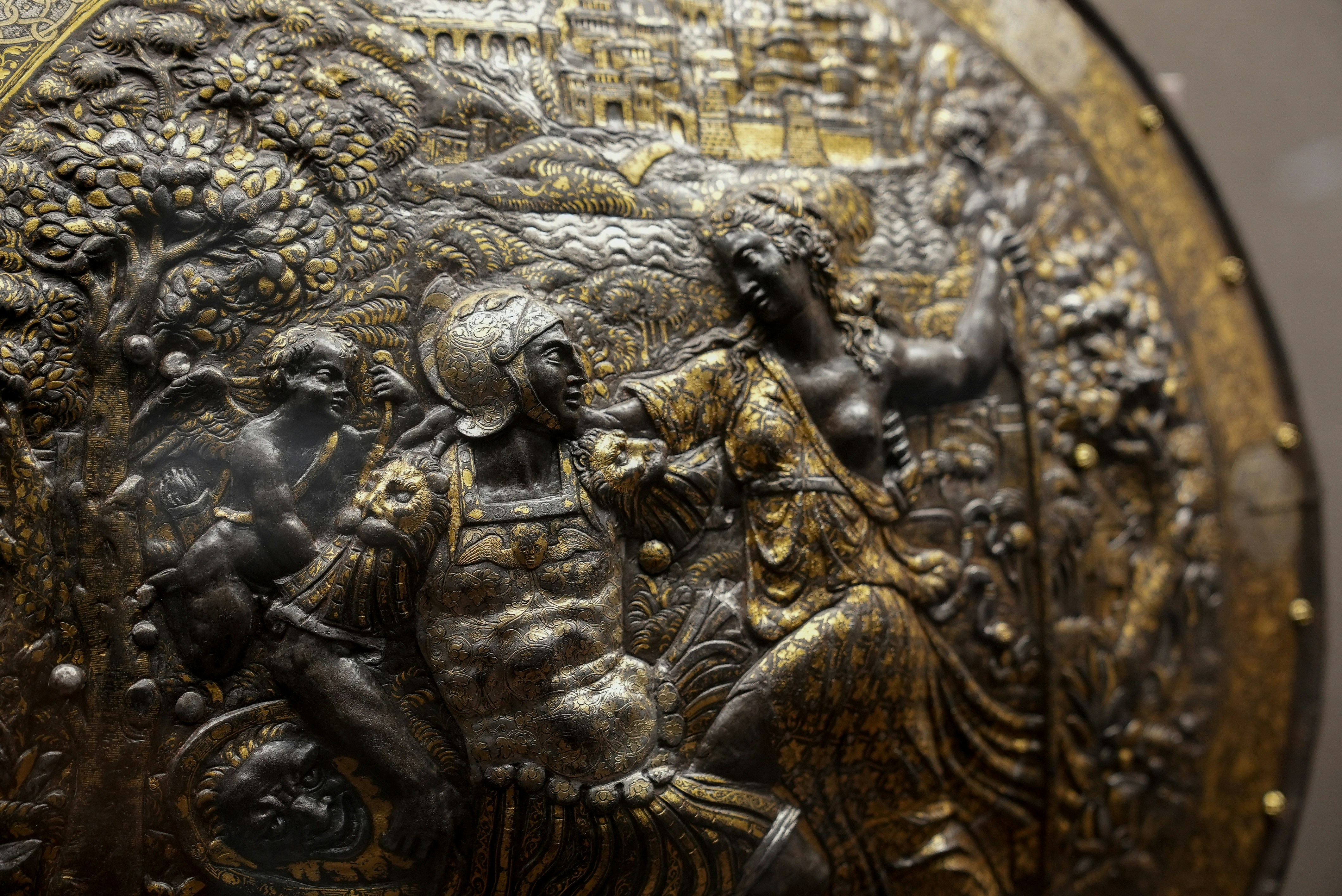 Intricate metal relief of a medieval battle scene.
