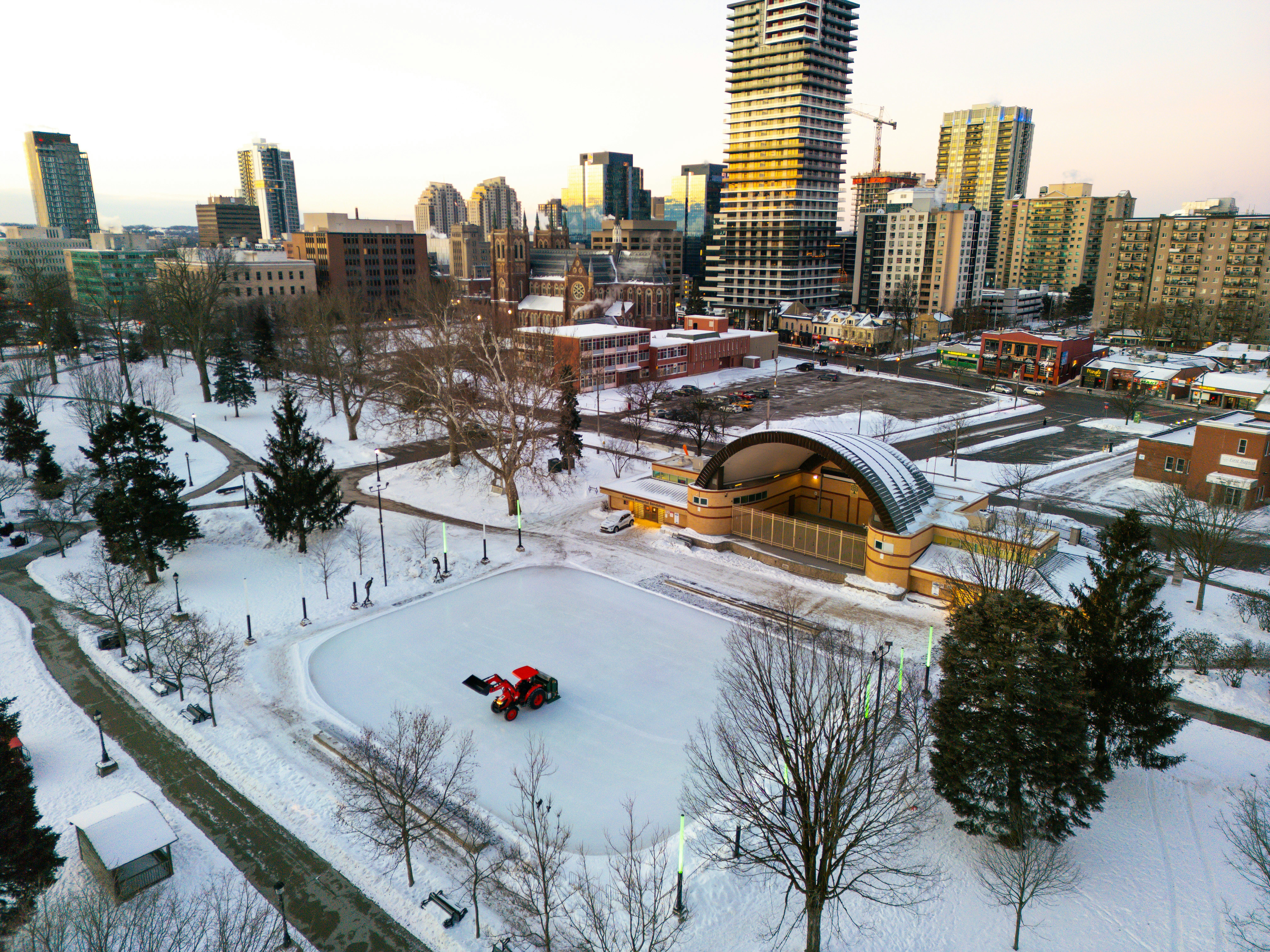 Winter park with ice rink and city skyline background