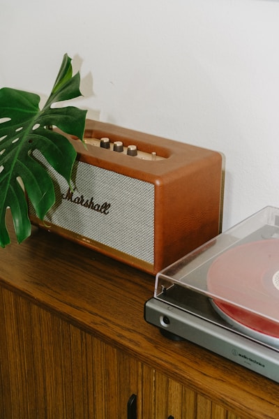 A vintage record player and Marshall speaker on a wooden cabinet, part of Book 615's curated vinyl collection