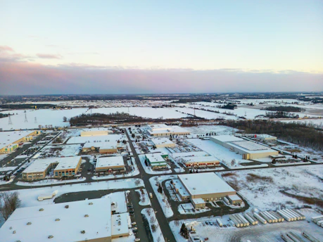 Aerial view of industrial buildings in a snowy landscape.