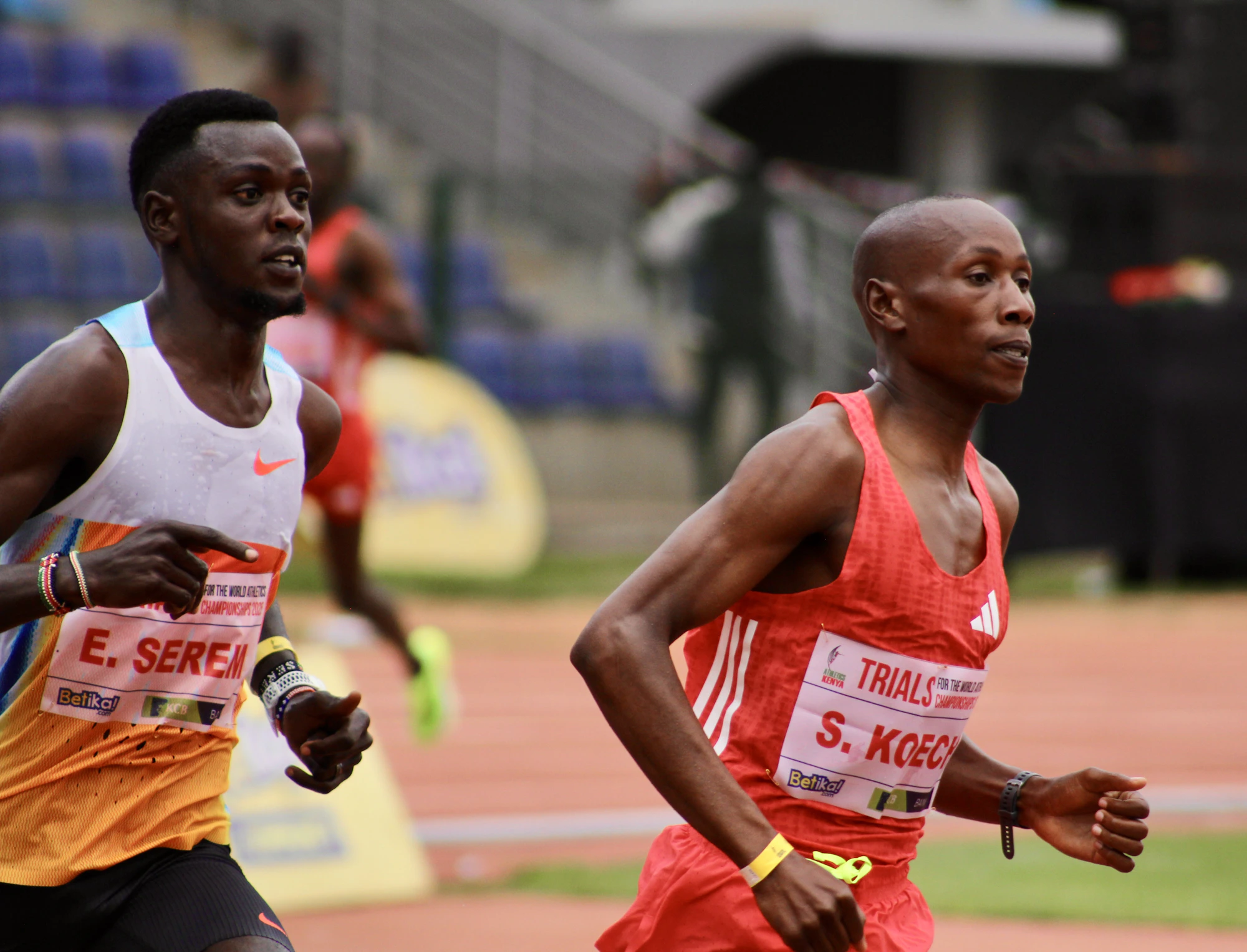 Two runners competing in a race on a track.