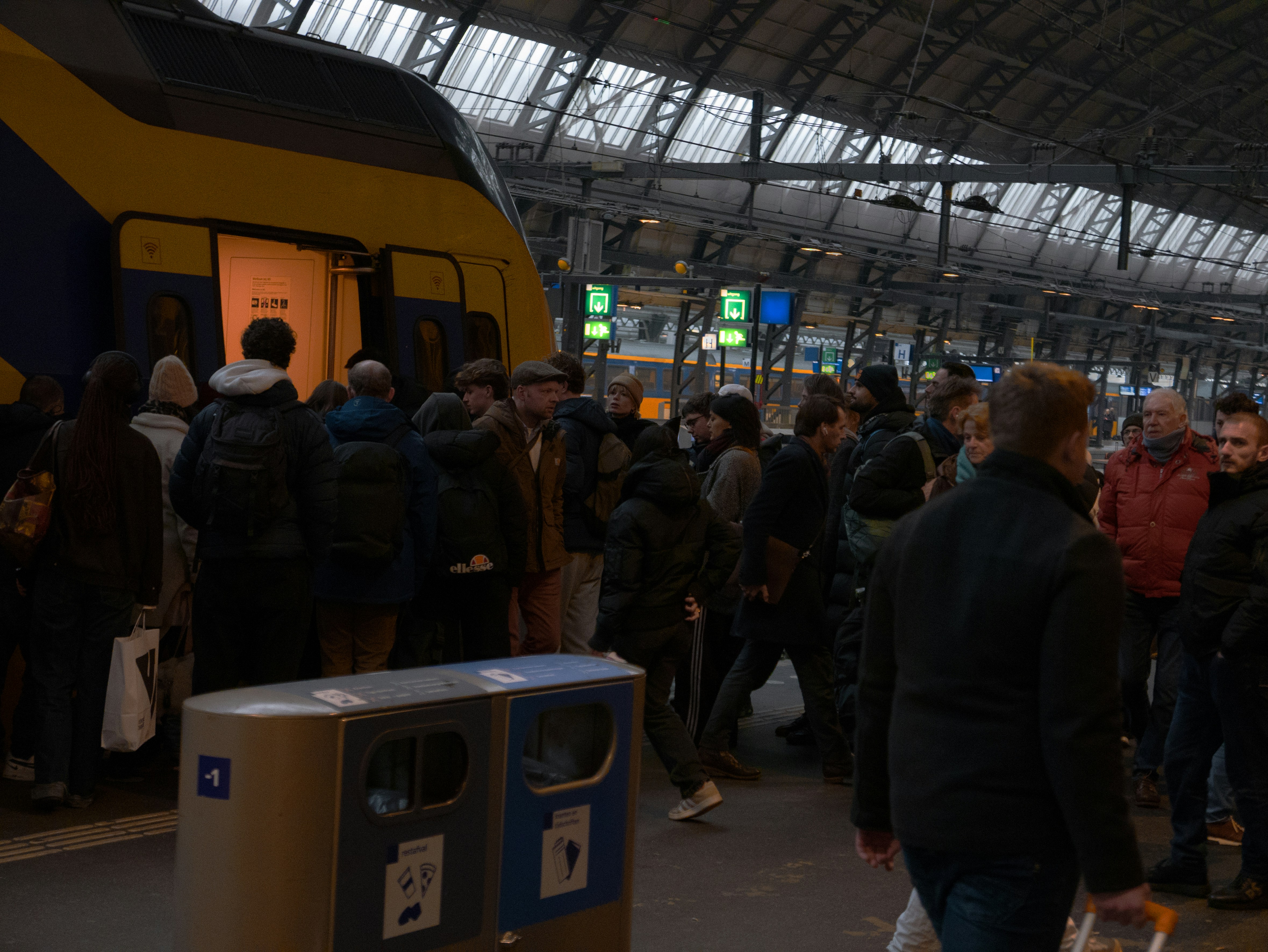People boarding a train at a busy station.