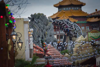 Roller coaster ride with asian-inspired architecture and lights