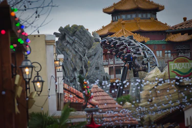 Roller coaster ride with asian-inspired architecture and lights