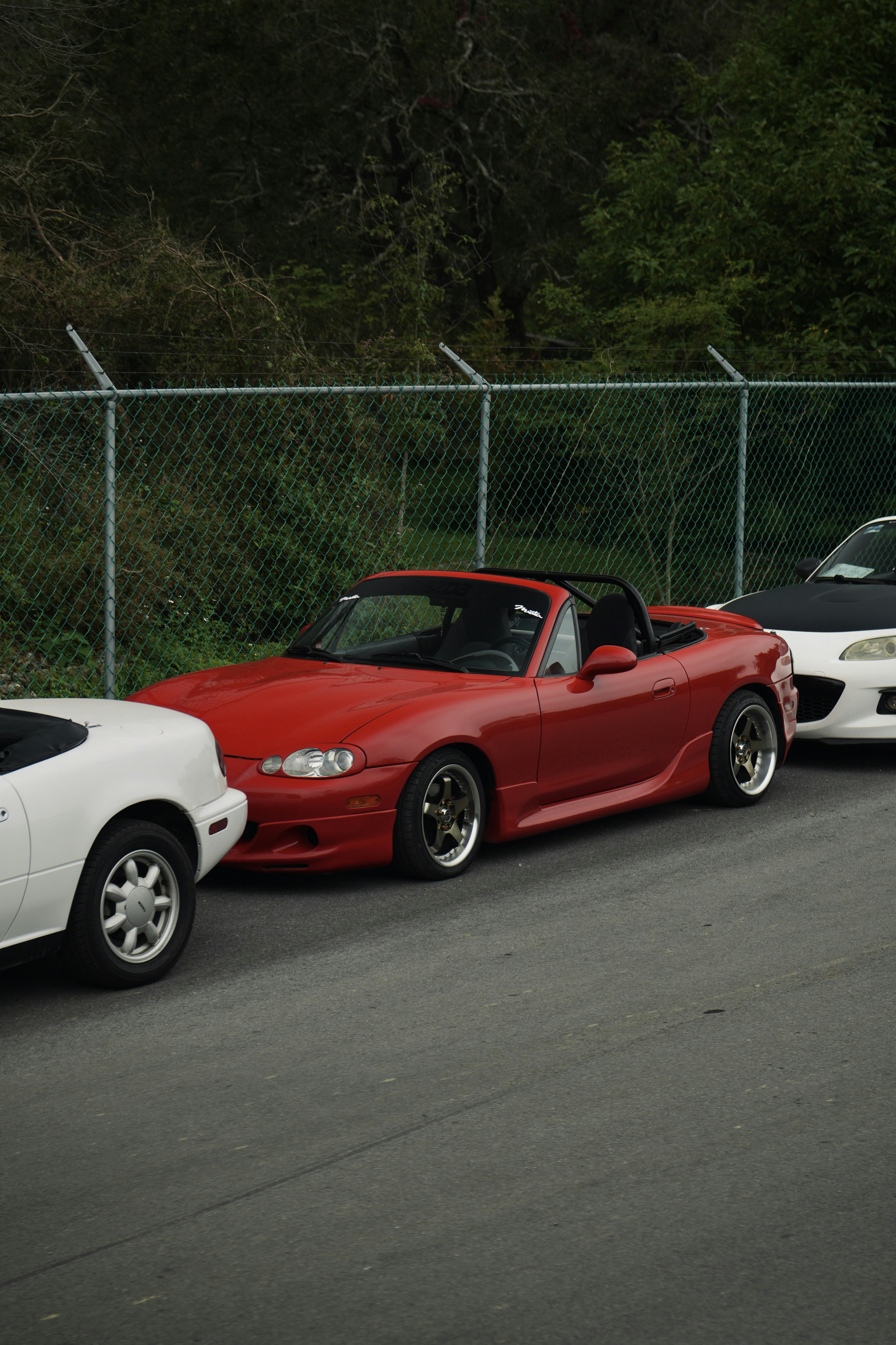 Tres coches deportivos descapotables aparcados en una fila.