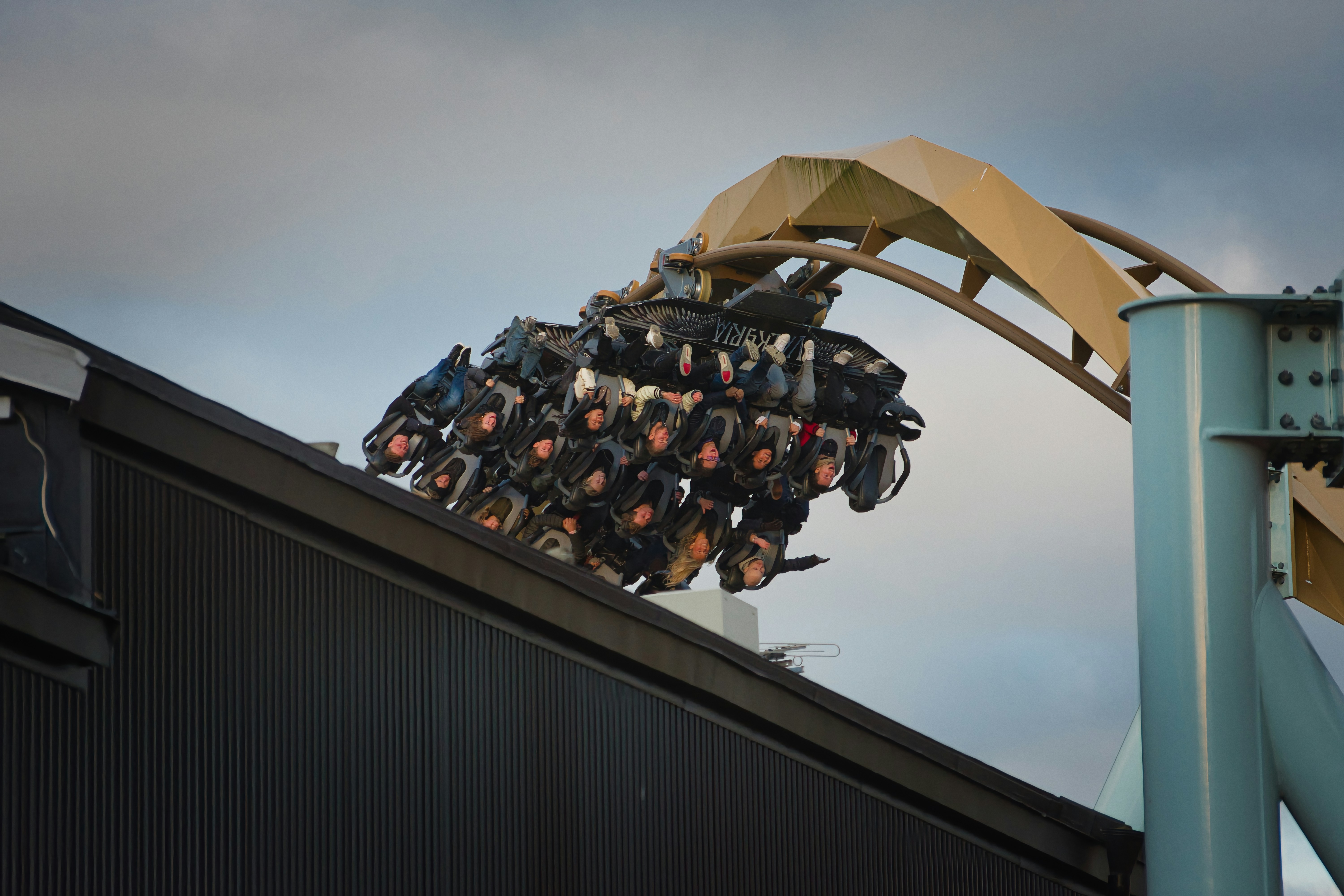 Roller coaster riders experience thrill on a cloudy day.