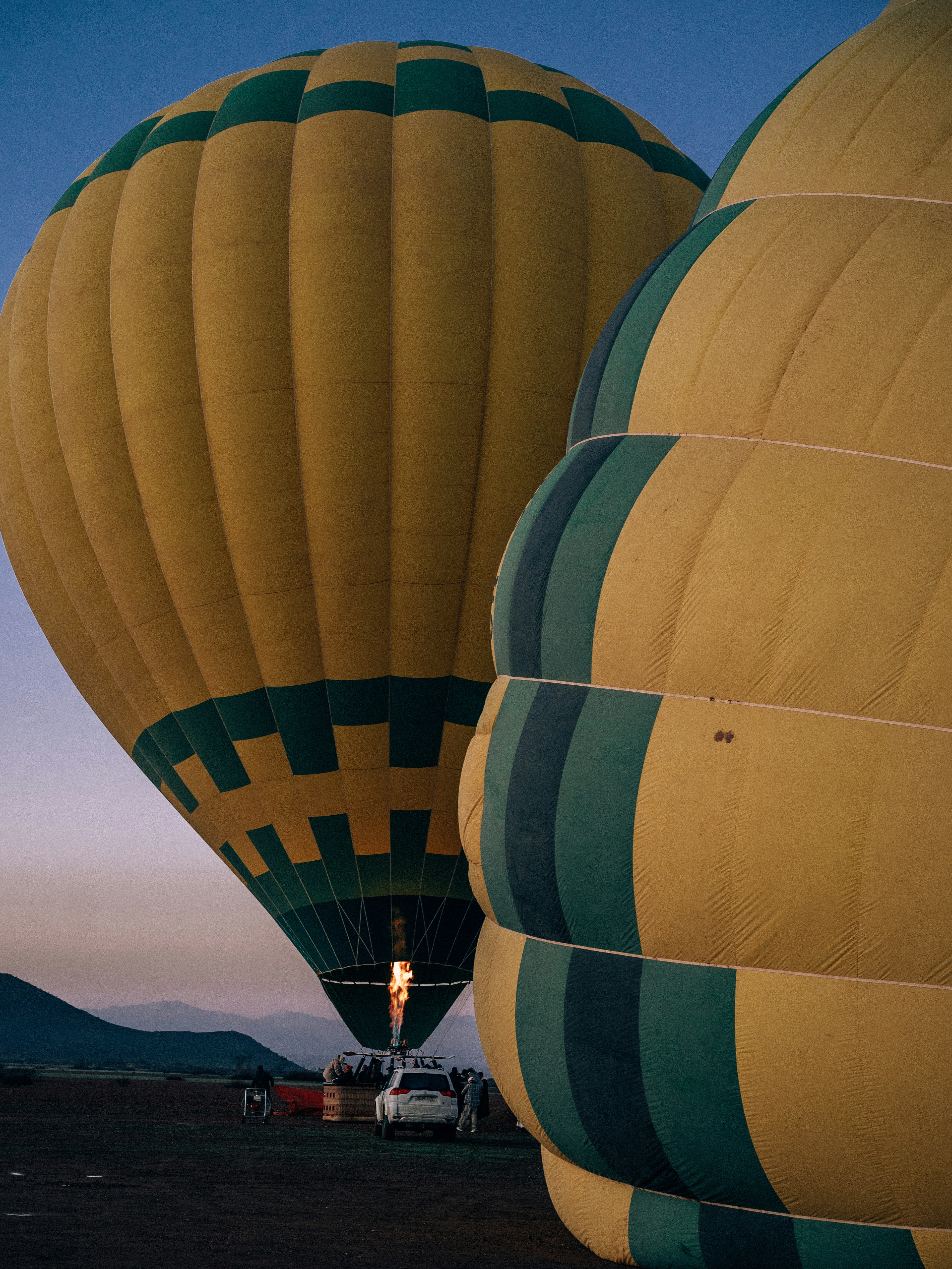 Due mongolfiere che si preparano al volo all'alba