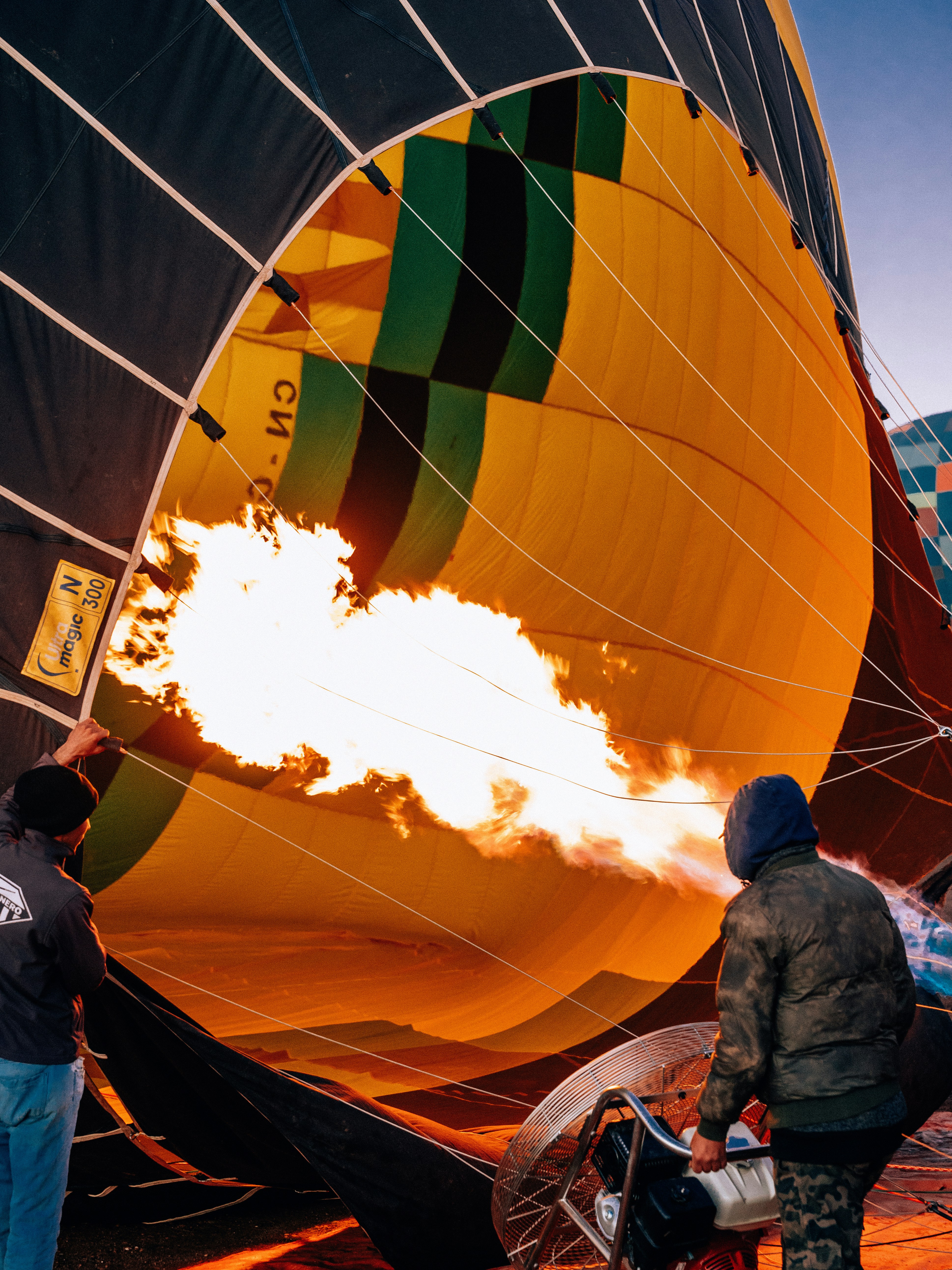 Persone che gonfiano una mongolfiera con il fuoco.