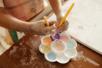 Hands mixing colorful paints on a palette