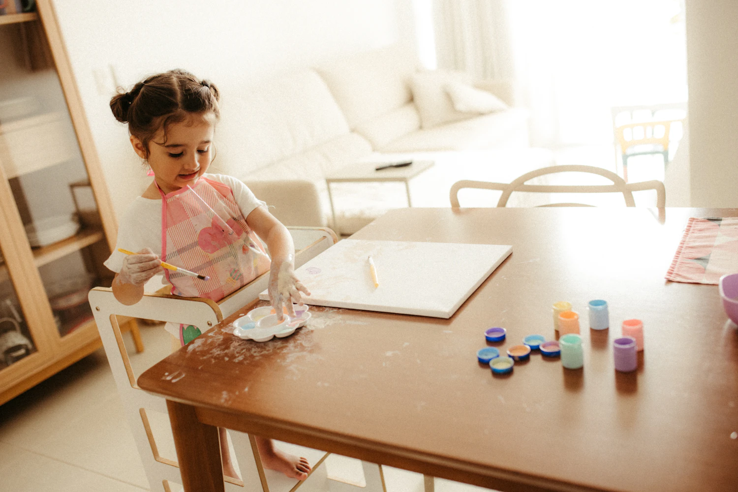 Young child sitting at a table working carefully on a craft project