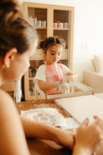 A child painting at a table with an adult