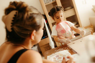 A mother watches her child making cookies