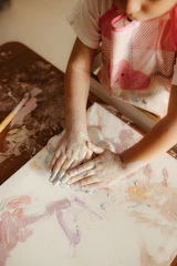 Child's hands covered in paint creating art