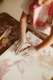 Child's hands covered in paint creating art