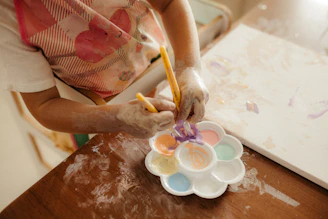 Child painting with watercolors on canvas