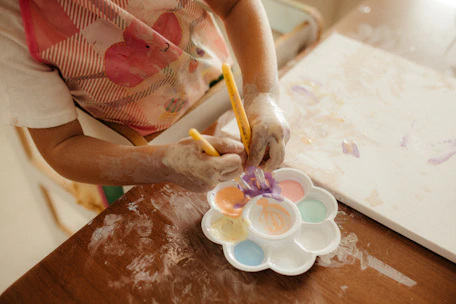 Child painting with watercolors on canvas