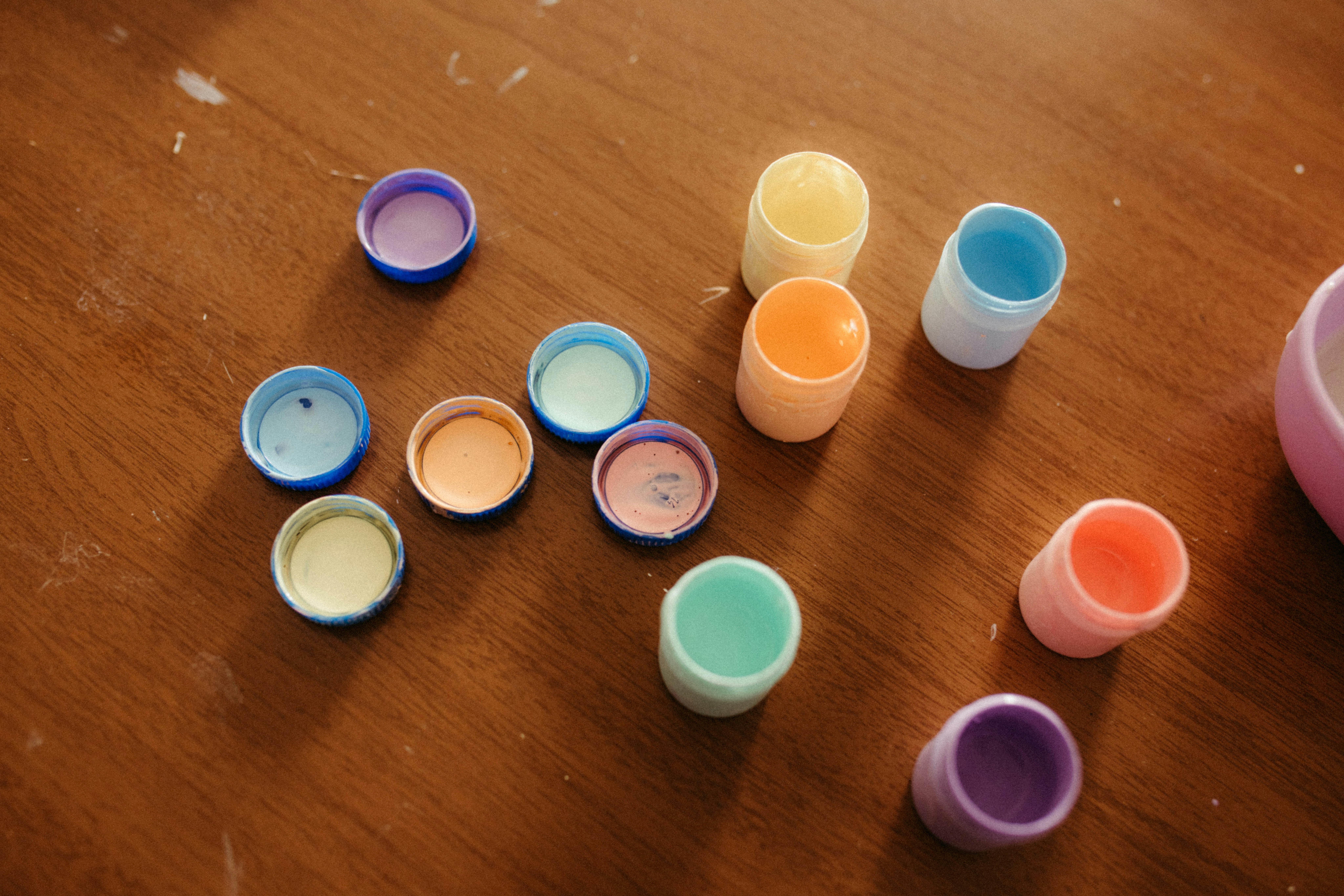 Bunte kleine Plastikkappen lagen auf einer Holzoberfläche verstreut