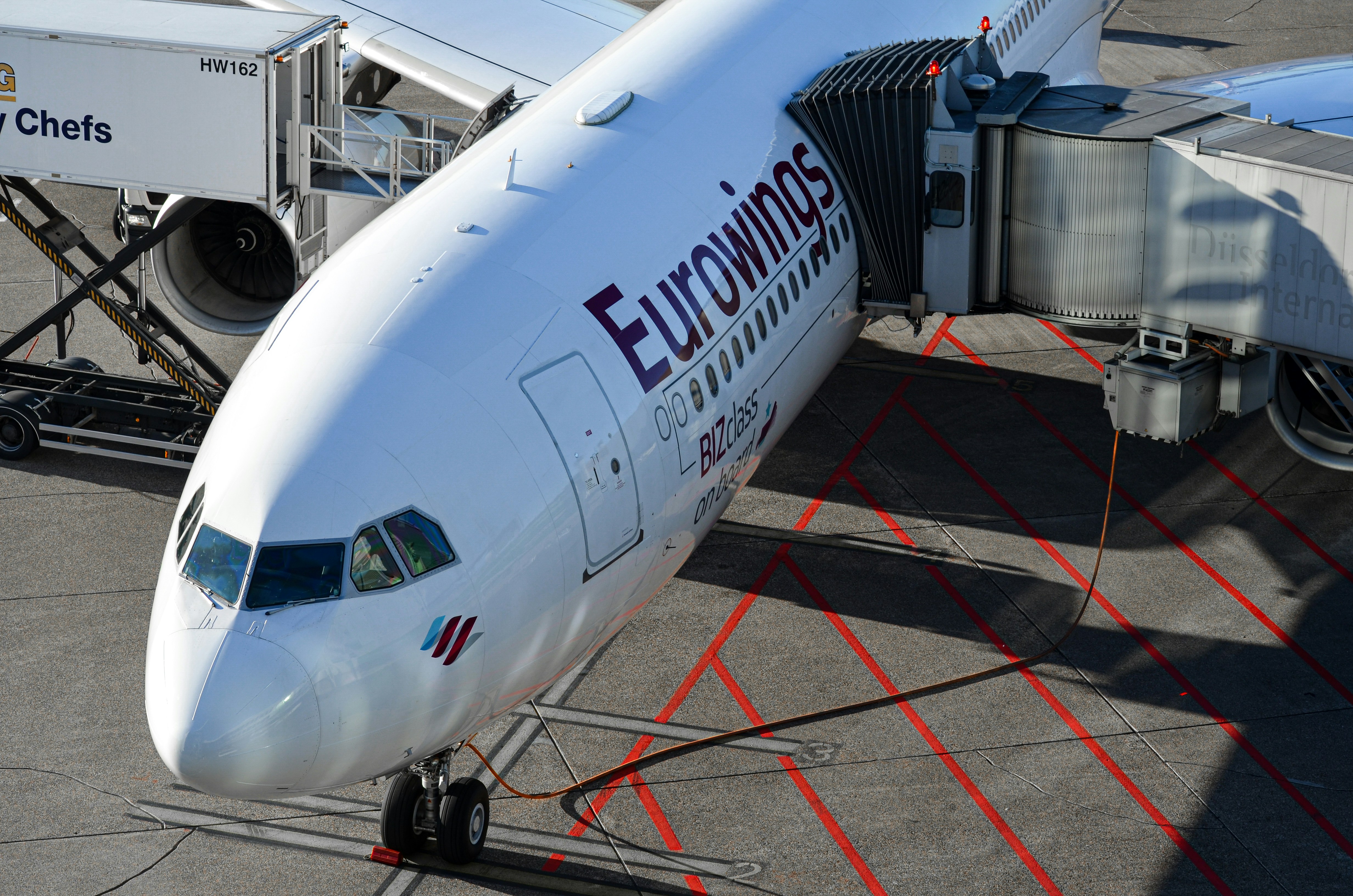 Eurowings airplane connected to a jet bridge at airport.
