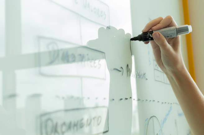 Hand drawing a diagram on a whiteboard