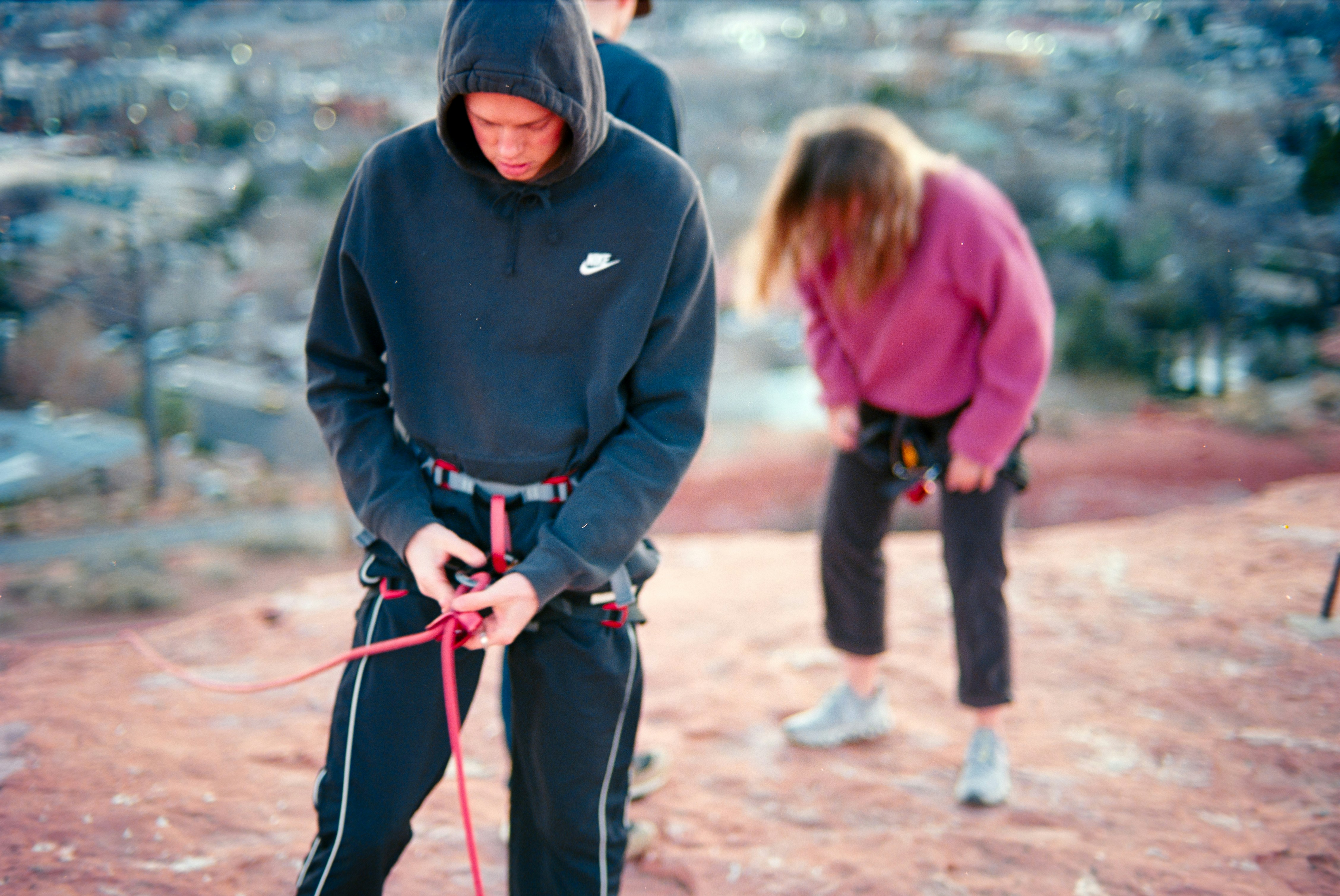 Young people preparing for rock climbing outdoors