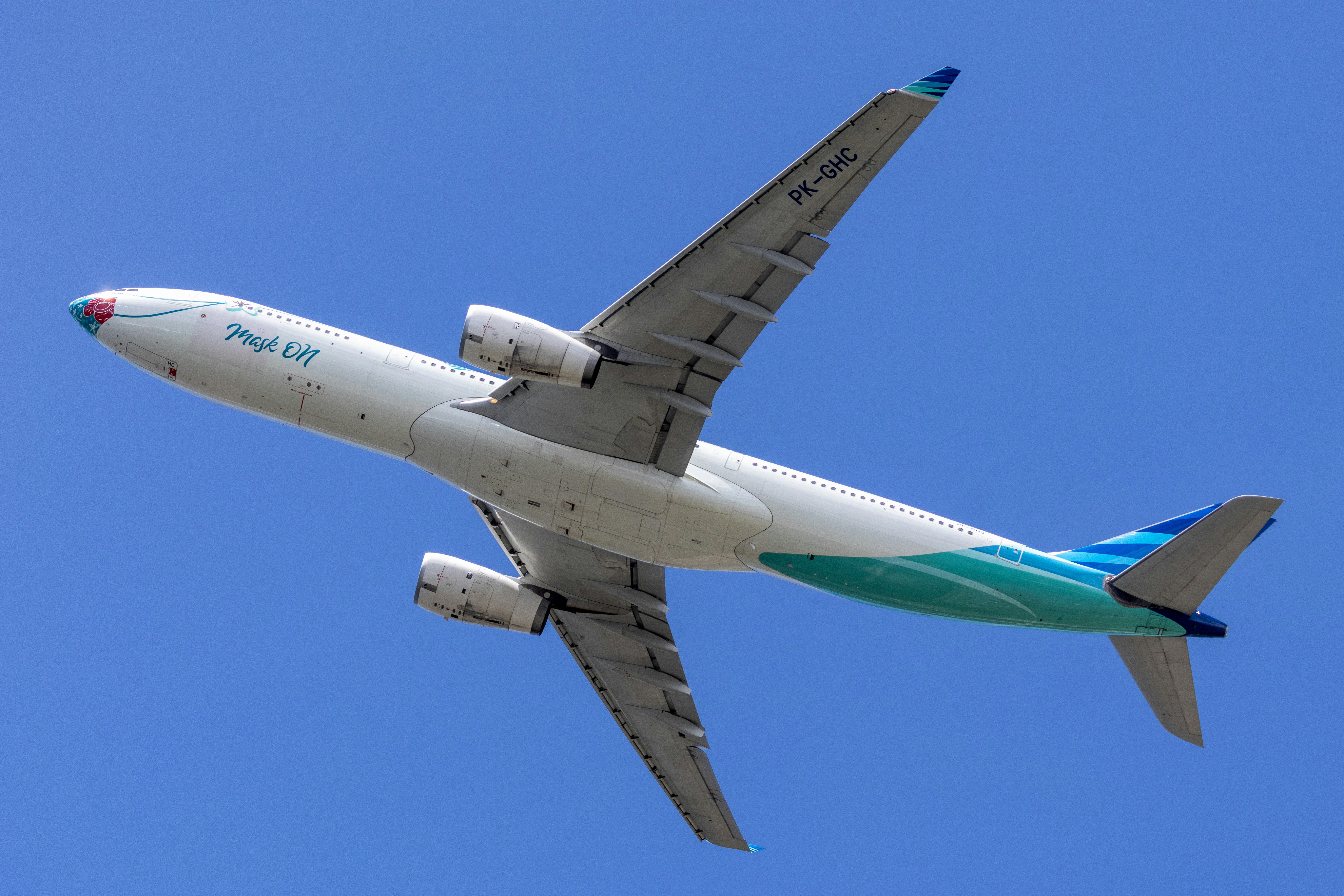 A commercial airplane flying in a clear blue sky
