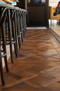 Row of bar stools above patterned wooden floor