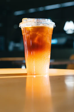 A layered iced coffee drink in a clear plastic cup.