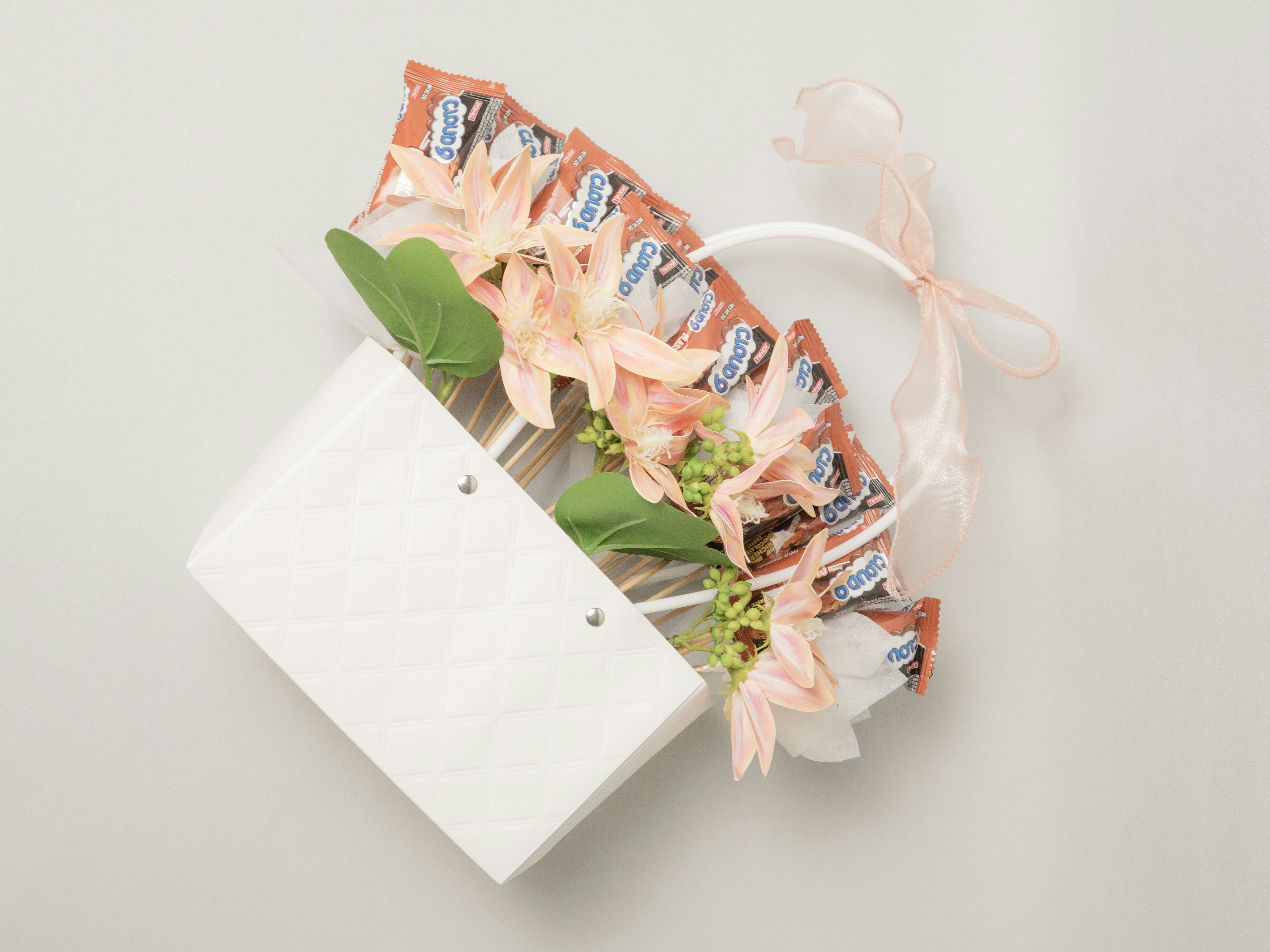 Small white gift bag with candy and flowers