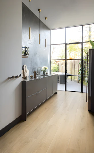 Modern kitchen with dark cabinets and large glass doors.