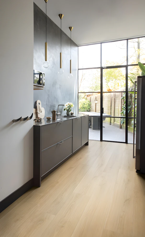 Modern kitchen with dark cabinets and large glass doors.
