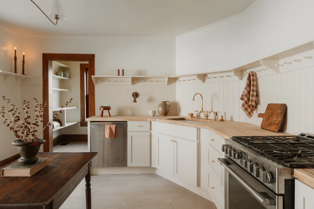 Cocina moderna con gabinetes blancos cálidos y encimeras de madera — tendencia de color 2026