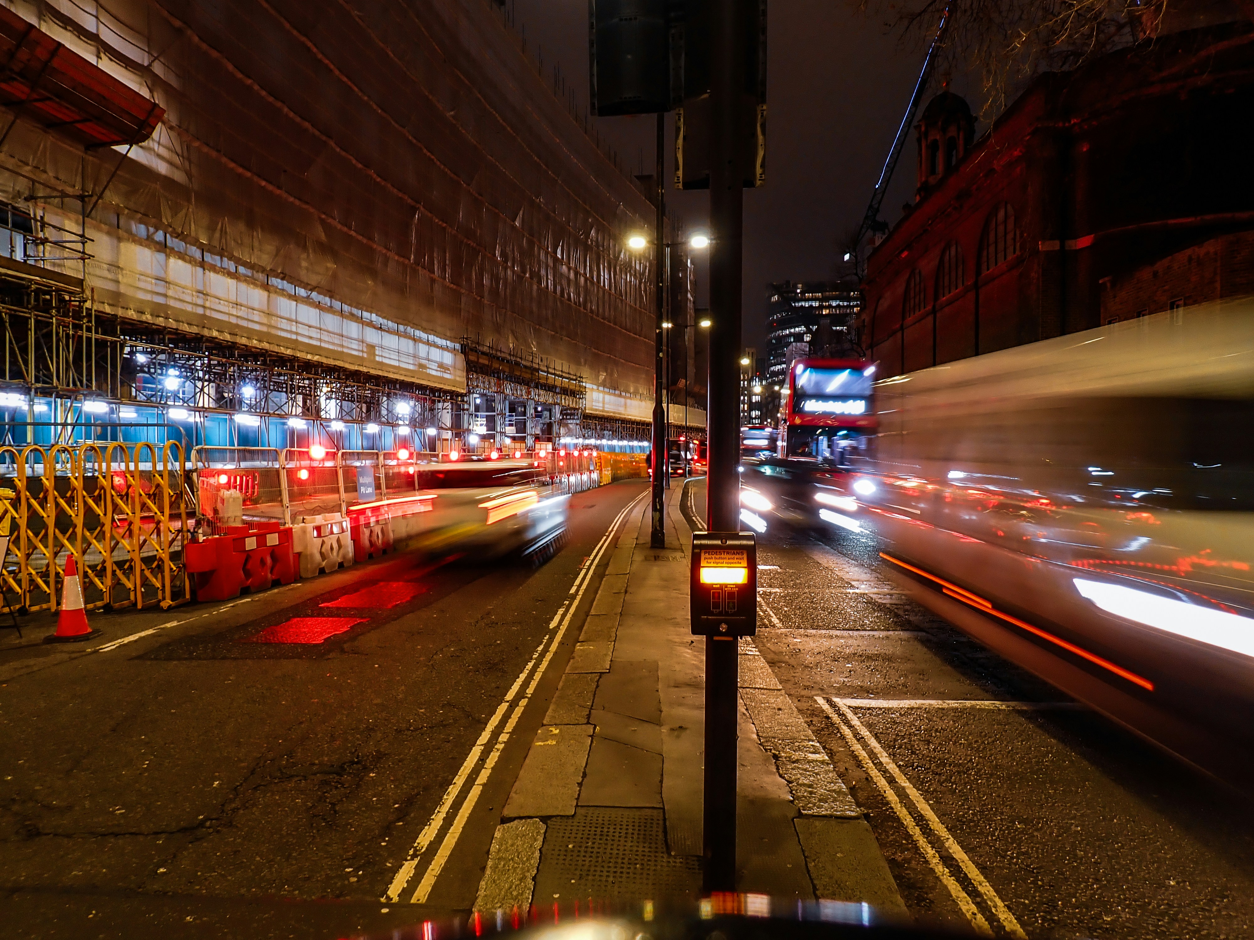 City street at night with blurred traffic lights and bus.