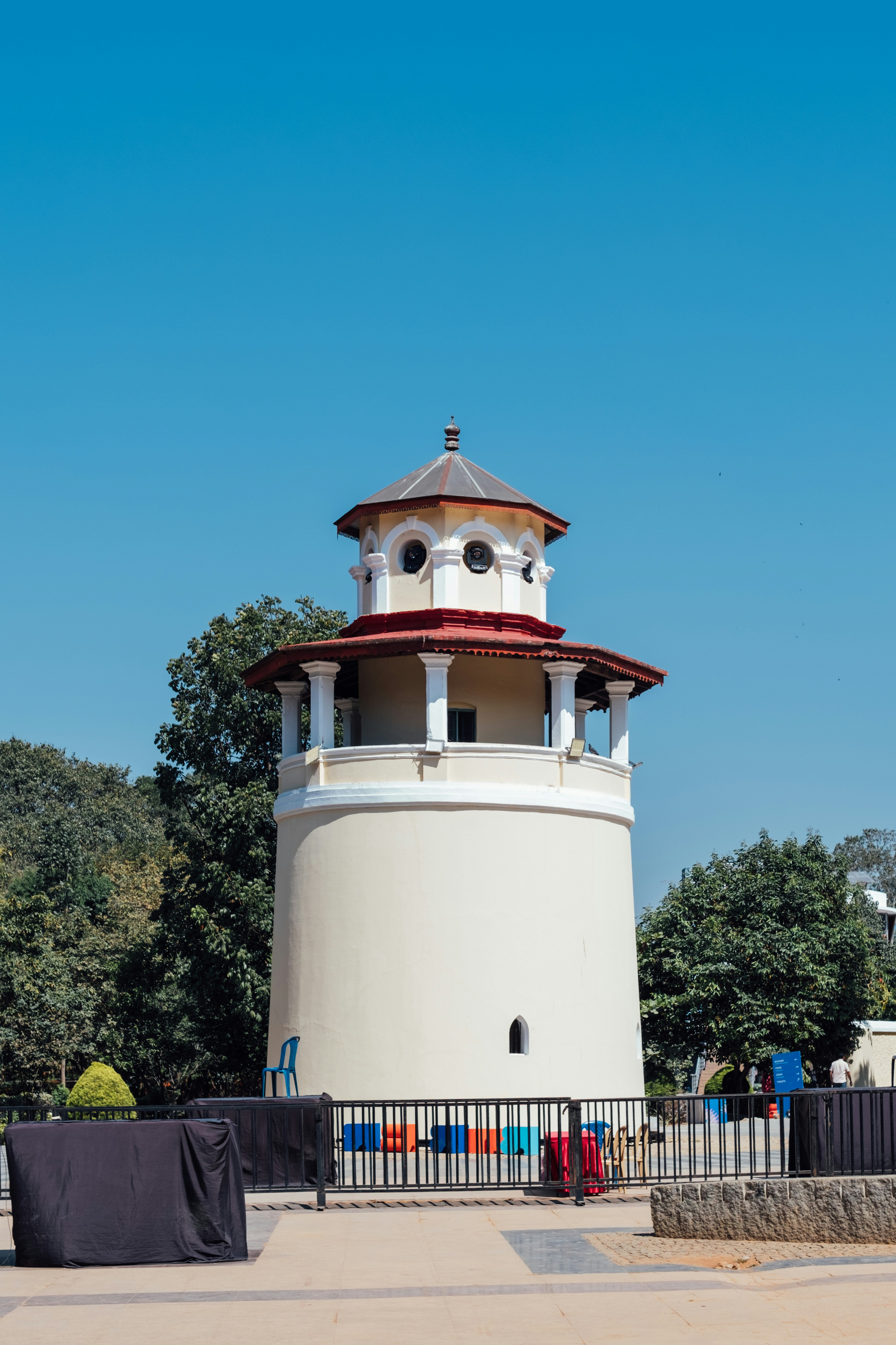 Cream colored tower with red roof under blue sky