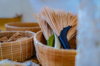 Brooms with black and green handles in a basket