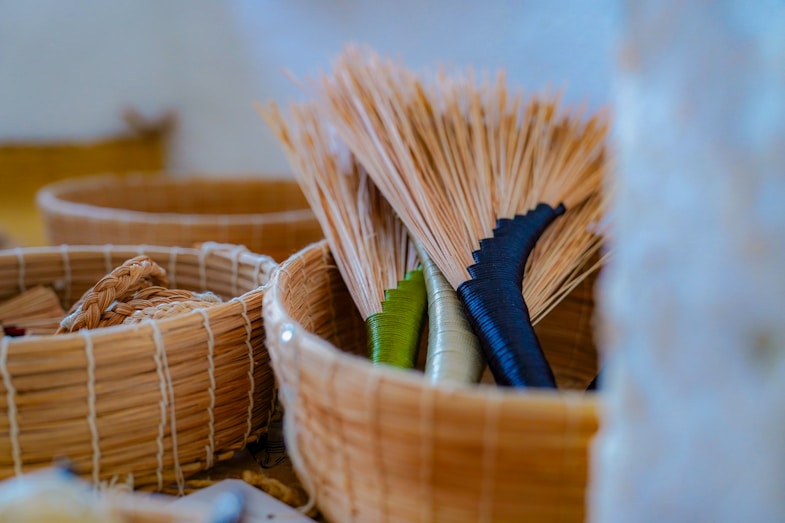 Brooms with black and green handles in a basket