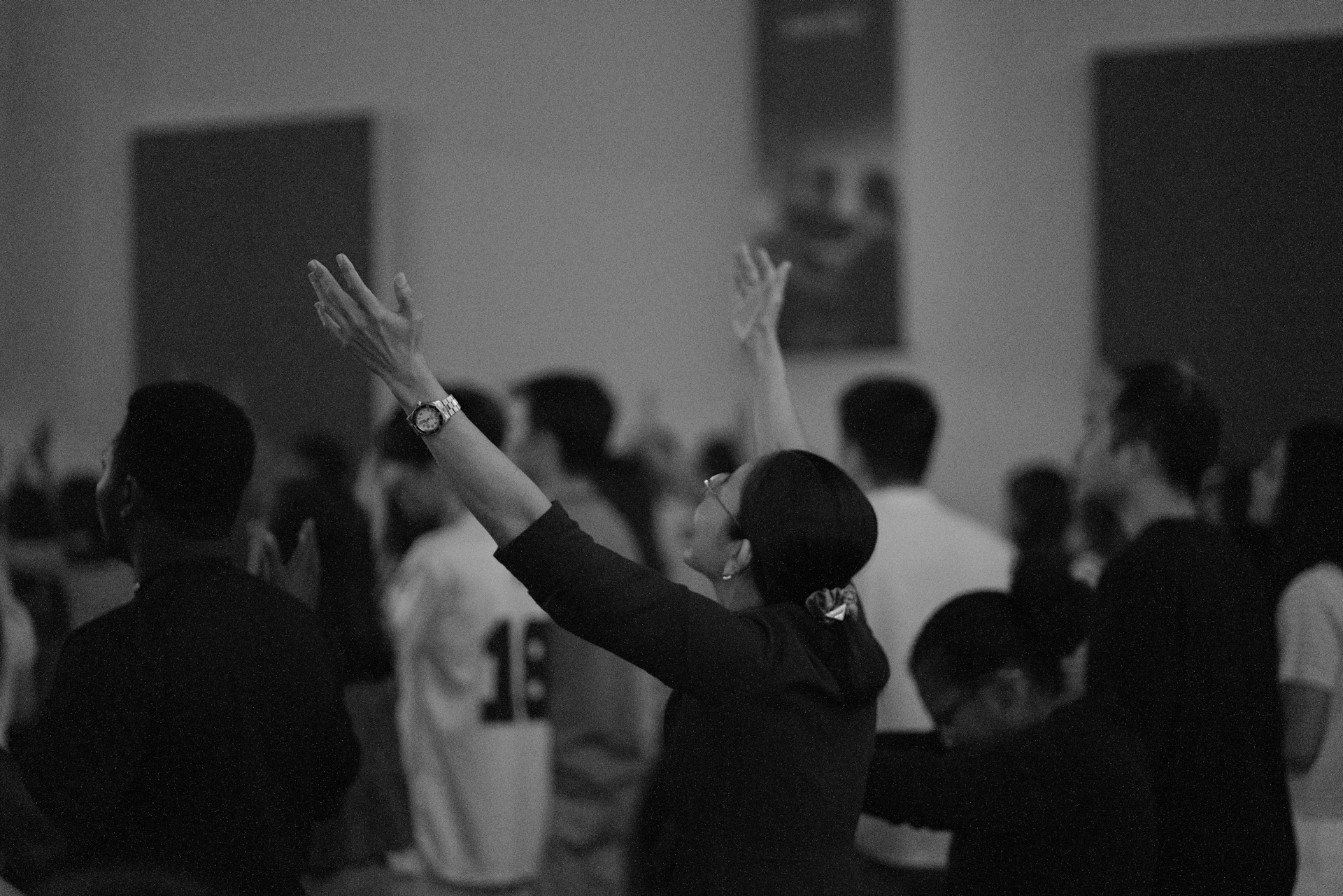 Woman with arms raised in worship among a crowd