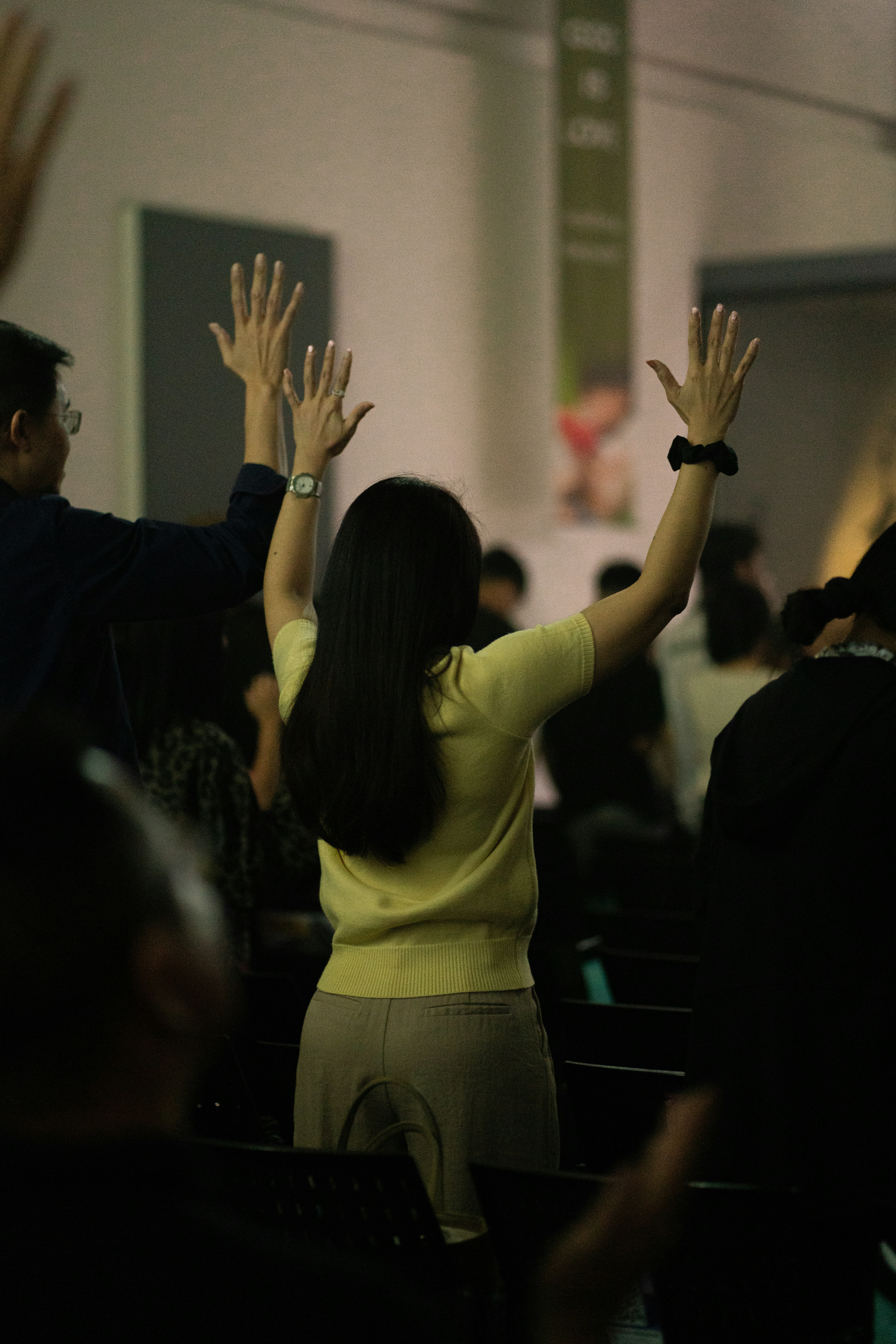 People raising hands in a worship service.